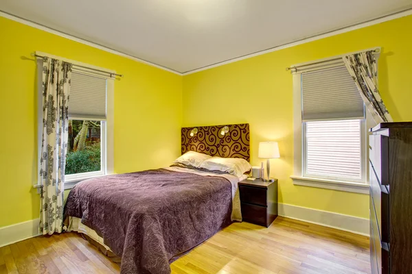 Interior kamar tidur dengan dinding kuning dan furnitur coklat dalam — Stok Foto