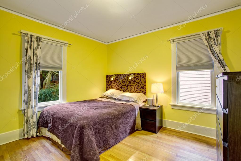 Bedroom interior with yellow walls and deep brown furniture Stock Photo