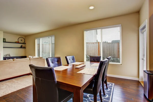 Zona de comedor con mesa de madera y sillas de cuero . — Foto de Stock