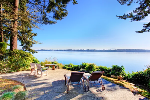 Backyard patio area with chairs, concrete walkway and amazing view. — Stock Photo, Image