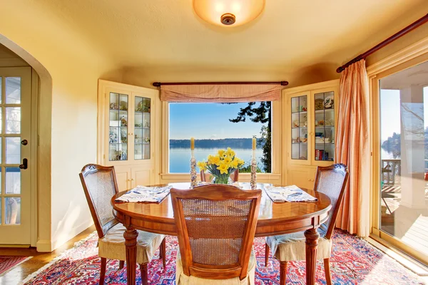 Comedor interior con mesa de madera. Increíble vista al agua . —  Fotos de Stock