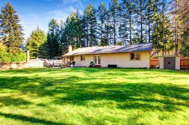 Veranda alanı ve bakımlı çimile geniş arka bahçe.