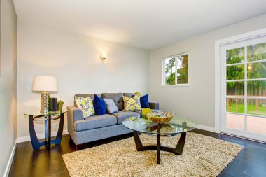 Parke zemin, bej halı ve modern mobilya ile oturma odası. 