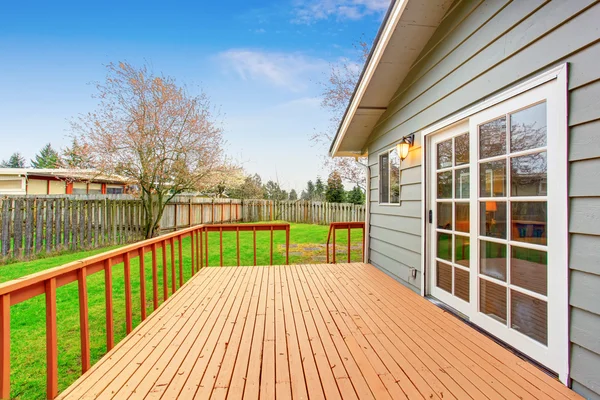 Casa de una planta con terraza de madera con vistas al jardín del patio trasero . —  Fotos de Stock