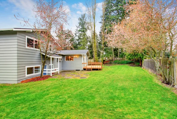 Maison de deux étages avec terrasse en bois. Cour arrière clôturée — Photo