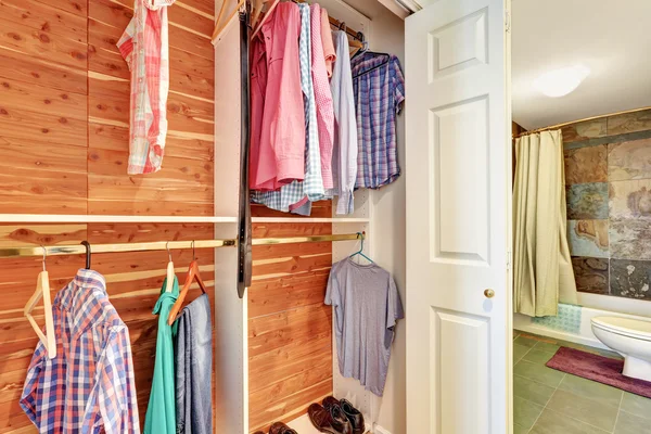 Vista de cerca de ropa y camisas en hangares de madera en un armario . — Foto de Stock