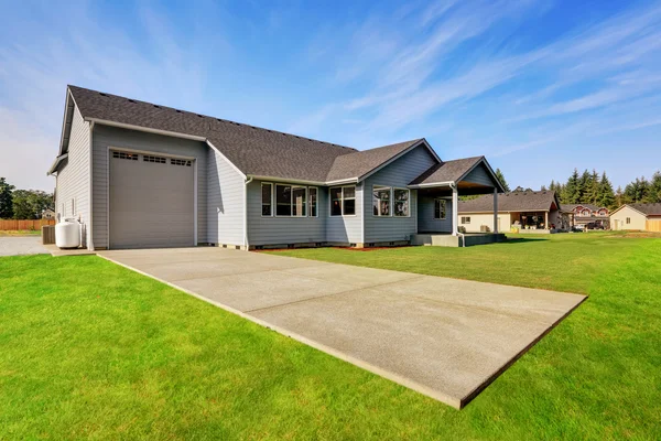 Backyard view of blue house with garage and green grass. — Stock Photo, Image