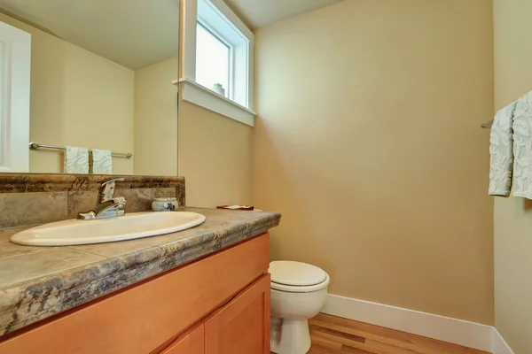 Setengah interior kamar mandi klasik dengan lemari kesombongan dan toilet . — Stok Foto