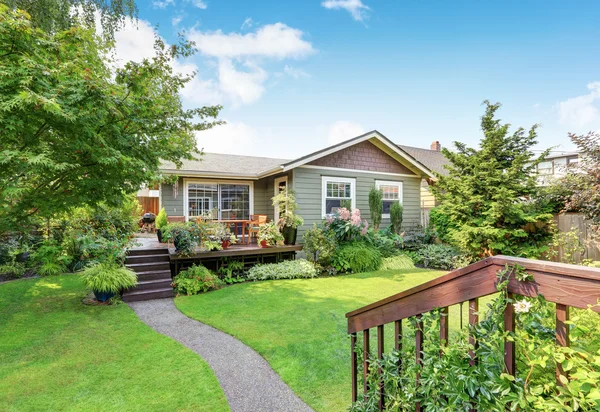 Uitzicht op pension met houten dek en mooi getrimd tuin — Stockfoto