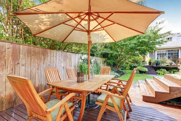 House exterior. Wooden patio table set with umbrella — Stock Photo, Image