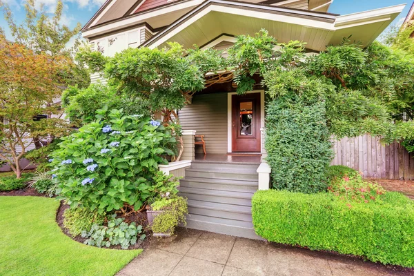 Cozy covered porch sinking in green bushes and trees. — Stock Photo, Image