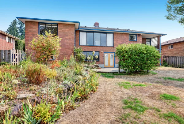 Rode bakstenen huis buitenkant. Omheinde achtertuin met betonnen vloer. — Stockfoto
