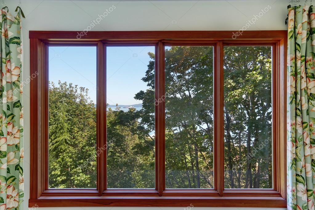 Primer plano de la gran ventana de cuatro paneles con paisaje de verano