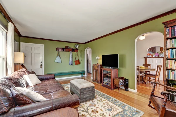 Murs verts salon avec canapé en cuir et porte d'entrée — Photo