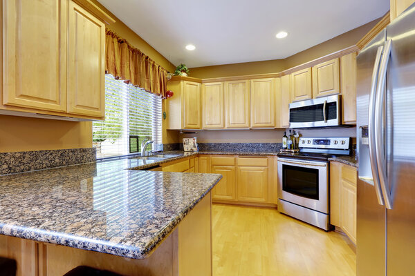 Light tones kitchen interior with modern steel appliances.