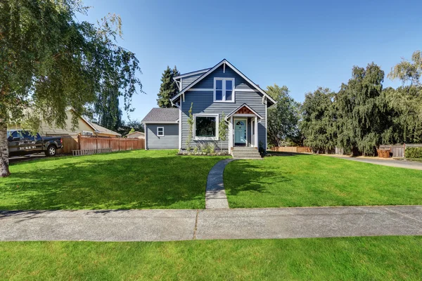 Blauwe duig siding huis met gras gevuld voortuin. — Stockfoto