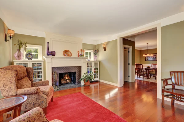 Bel soggiorno con mobili vintage e tappeto rosso . — Foto Stock