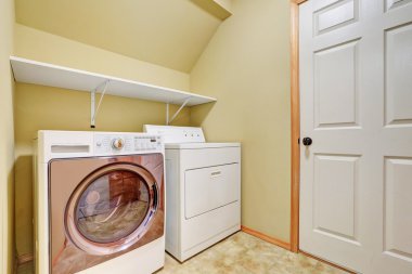 White appliances in a laundry room with vaulted ceiling.