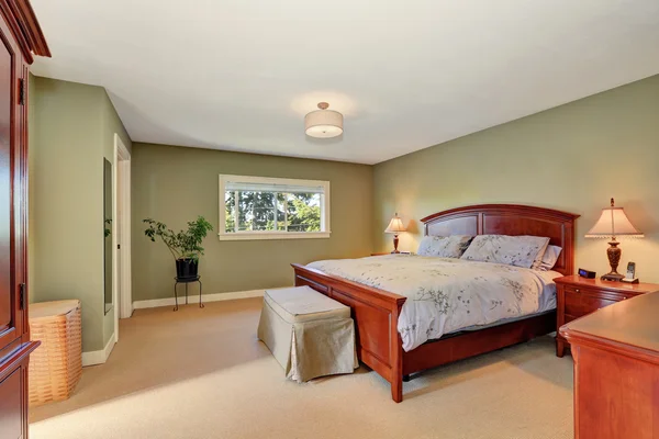 Vue du lit king size en bois dans l'intérieur de la chambre à coucher olive . — Photo