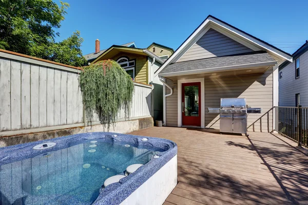 Wooden walkout deck with hot tub and barbecue