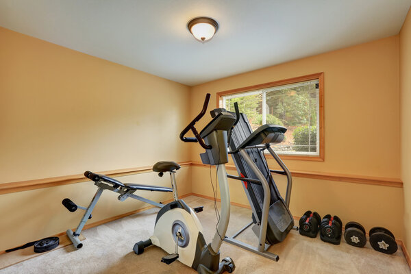 Small gym room with exercise equipments.