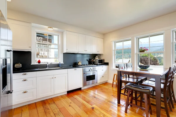 Design of kitchen room interior with white cabinets and black counter tops — Stock Photo, Image