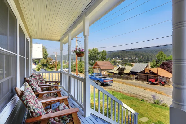 White covered porch with columns and stairs overlooking neighborhood — 스톡 사진