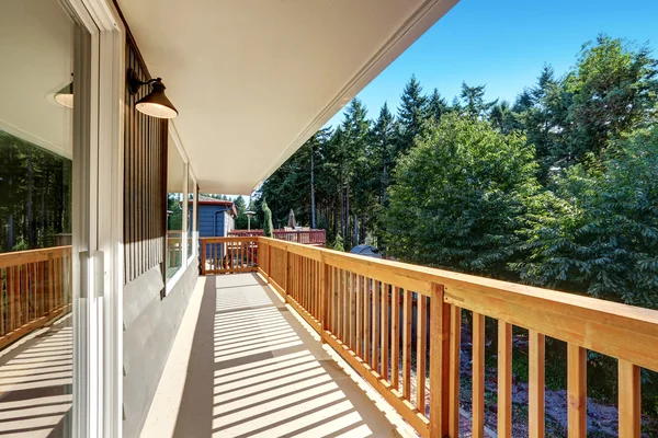 Long empty deck with wooden railings and backyard view. — Stock Photo, Image