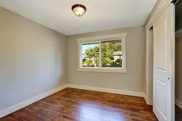 Quarto vazio com piso em parquet de madeira, janela e armário . — Fotografia de Stock