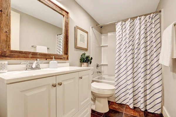 Salle de bain blanche avec meuble vanité et miroir encadré en bois . — Photo