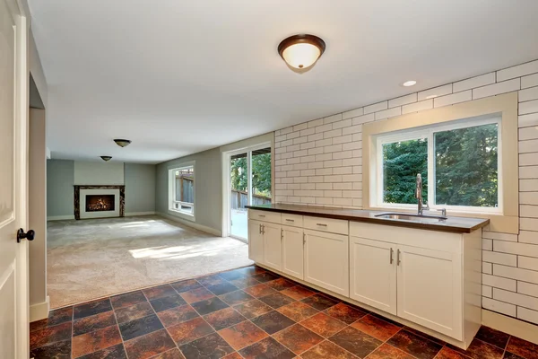 Habitación vacía con lavabo y suelo de baldosas marrones . — Foto de Stock