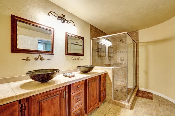 Bathroom with beige tile trim and glass shower. — Stockfoto