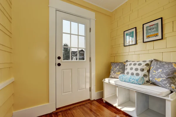 Entryway med gula väggar och förvarings bänk i vitt — Stockfoto