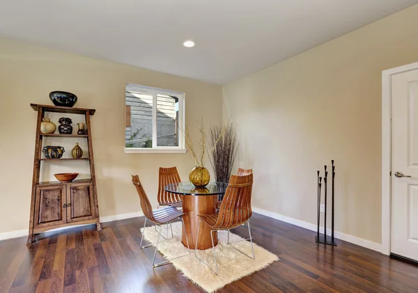 Dining room with round glass table and wooden chairs — Stock Photo, Image