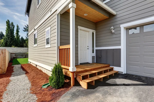 Pequeño porche delantero con escaleras y puerta de entrada blanca . — Foto de Stock