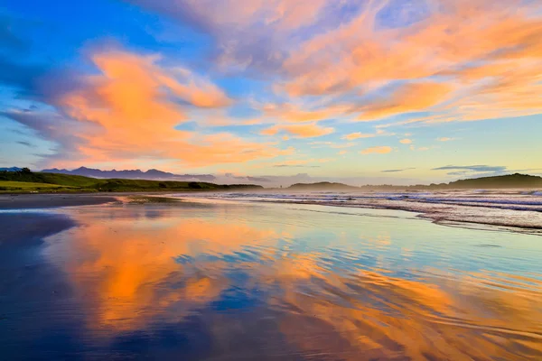 Homokos strand és a narancs felhők Westport, Új-Zéland — Stock Fotó