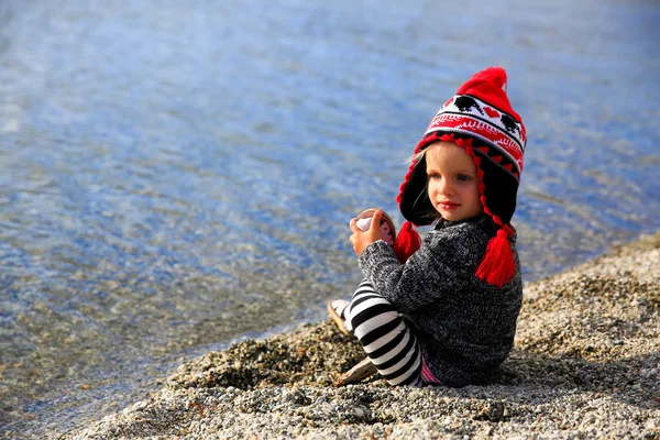 Kleines Mädchen sitzt am Sandstrand. Lake wanaka, Neuseeland — Stockfoto