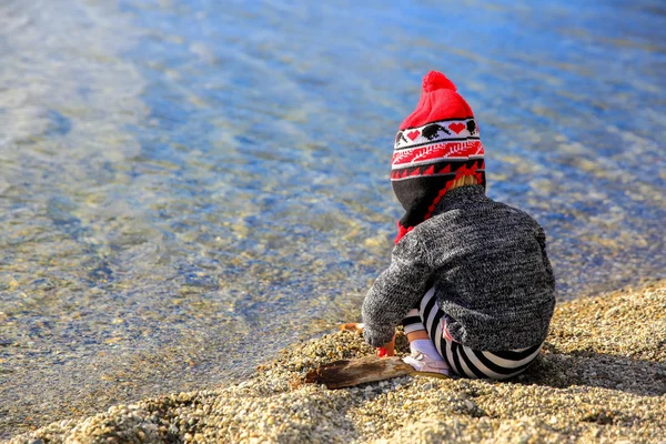 Bambina sta giocando vicino all'acqua del lago Wanaka, Nuova Zelanda — Foto Stock