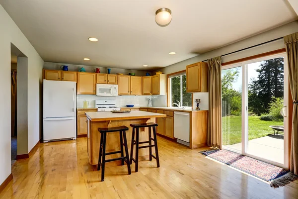 Interior da sala de cozinha com armários castanhos claros e ilha . — Fotografia de Stock