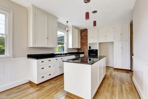 Klassieke keuken kamer interieur met witte kasten en donkere counter top. — Stockfoto