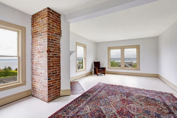 Interior de la habitación tradicional vacía en tonos blancos con chimenea de ladrillo y alfombra —  Fotos de Stock