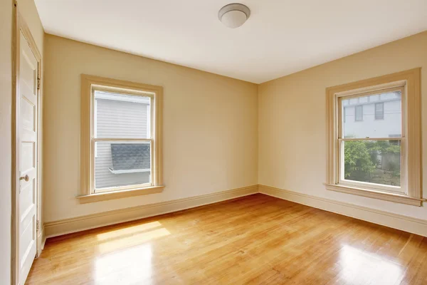 Interior do quarto vazio em paredes tom bege e piso de madeira brilhante . — Fotografia de Stock