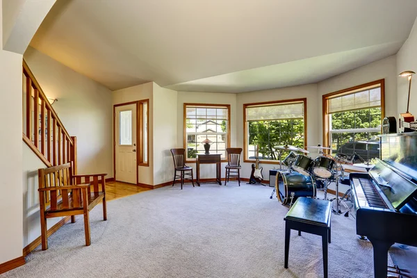 Muzikant van kamer interieur met drumstel, gitaar en piano. Stockfoto