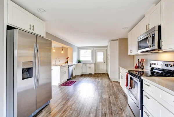 Planta abierta sala de cocina blanca con piso de madera pulida —  Fotos de Stock