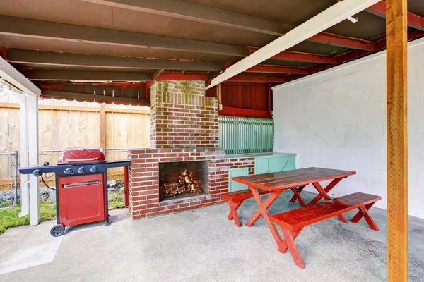 Exterior covered patio with brick fireplace and furniture. — Stock Photo, Image