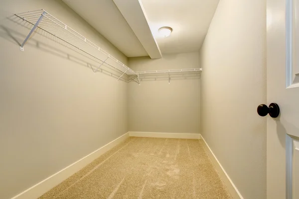 Empty narrow walk-in closet with shelves and carpet floor. — Stock Photo, Image