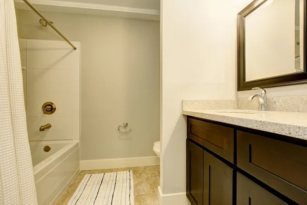 Badkamer interieur in witte tinten met zwarte ijdelheid kabinet. — Stockfoto