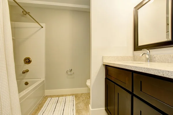 Bathroom interior in white tones with black vanity cabinet. — Stock Photo, Image