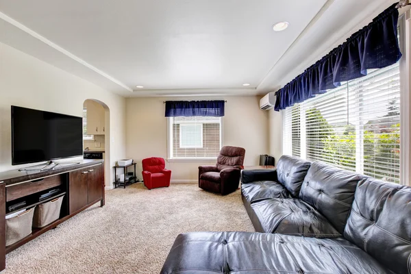 Cozy living room interior with black leather couch and tv set — Stock Photo, Image