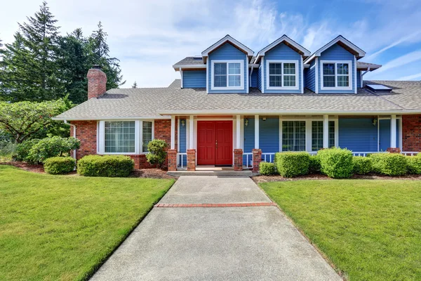 Exterior de la casa americana con acabado azul y blanco. También puerta delantera roja — Foto de Stock